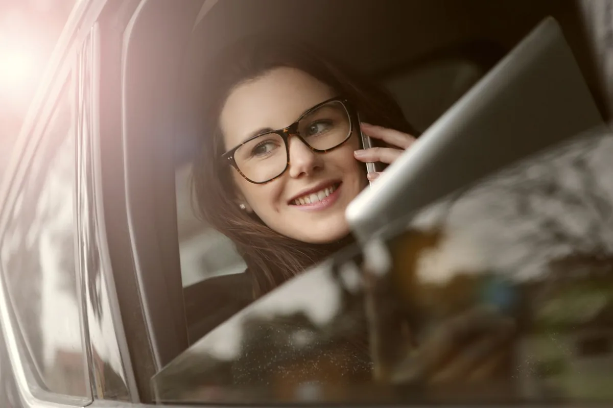 Driver on the phone in a car getting a Nebraska SR-22 insurance quote